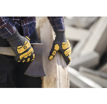 Person mit Arbeitshandschuhen hält eine Axt.