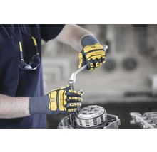 Eine Person repariert mit Handschuhen und Schraubenschlüssel einen Motor.