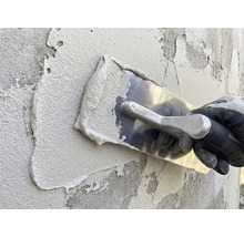 Putzauftrag mit Glättkelle auf einer Wand