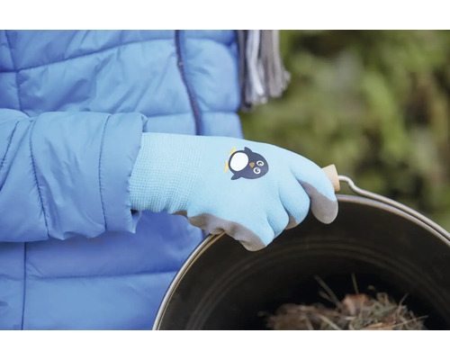 Eine Person trägt Gartenhandschuhe mit Pinguin-Motiv und hält einen Eimer.