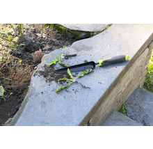 Gartengerät und Unkraut auf Steinstufen