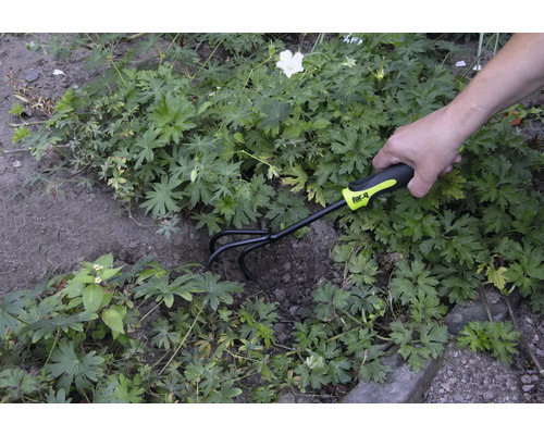 Gartenarbeitsszene mit einer Person, die eine Gartenkralle der Marke for_q zur Bodenbearbeitung verwendet.