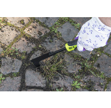 Person entfernt Unkraut mit einem Fugenkratzer von for_q zwischen Pflastersteinen.