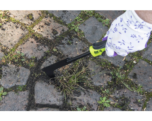 Person entfernt Unkraut mit einem Fugenkratzer von for_q zwischen Pflastersteinen.
