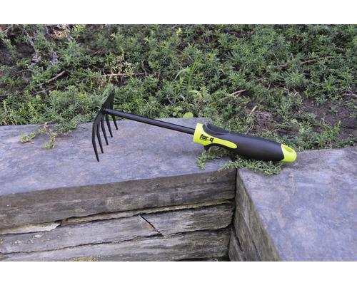 Laub- und Gartenrechen mit Zinken und Kunststoffgriff auf Steinmauer