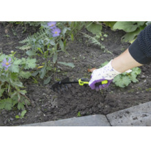Person verwendet einen kleinen Rechen zur Gartenarbeit