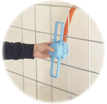 Hand befestigt eine blaue Unterputzdose mit Abstandshalter an einem Metallgitter für Elektroinstallationen.