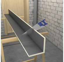 Blaue Handsäge schneidet ein L-förmiges Bauplattenelement mit grauer Gitteroberfläche auf Holzböcken in einem hellen, unfertigen Raum.