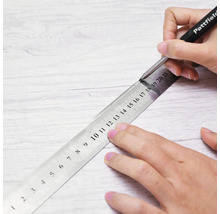 Markieren einer Linie auf einer Holzoberfläche mit einem Pattfield Markierstift und einem Metalllineal.