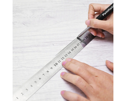 Markieren einer Linie auf einer Holzoberfläche mit einem Pattfield Markierstift und einem Metalllineal.