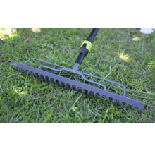 Gartenrechen aus Metall auf einer grünen Rasenfläche.