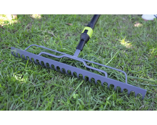 Gartenrechen aus Metall auf einer grünen Rasenfläche.