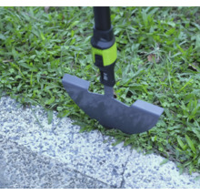 Rasenkantenstecher im Einsatz an einer Rasenkante zwischen Gras und gepflastertem Weg.