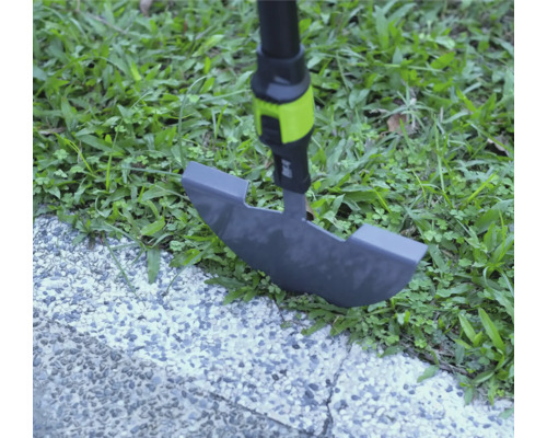 Rasenkantenstecher im Einsatz an einer Rasenkante zwischen Gras und gepflastertem Weg.
