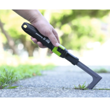 Fugenkratzer for_q fitconnect im Einsatz beim Entfernen von Unkraut zwischen Steinplatten im Garten.