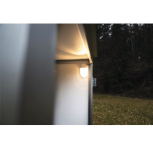 Hell leuchtende LED-Innenbeleuchtung montiert an der Wand im Inneren eines Metallgerätehauses in einem Garten.