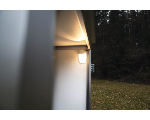 Hell leuchtende LED-Innenbeleuchtung montiert an der Wand im Inneren eines Metallgerätehauses in einem Garten.