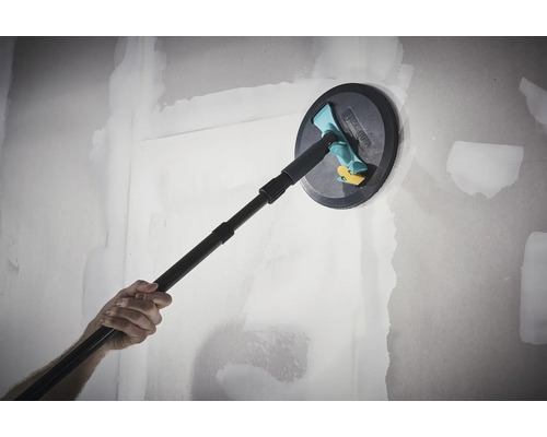 Wolfcraft Handschleifer mit Teleskopstange beim Schleifen einer gespachtelten Wand aus Gipskarton.