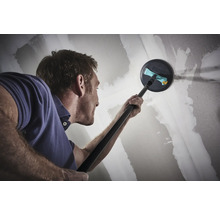 Ein Mann schleift eine Trockenbauwand mit einem Langhalsschleifer.