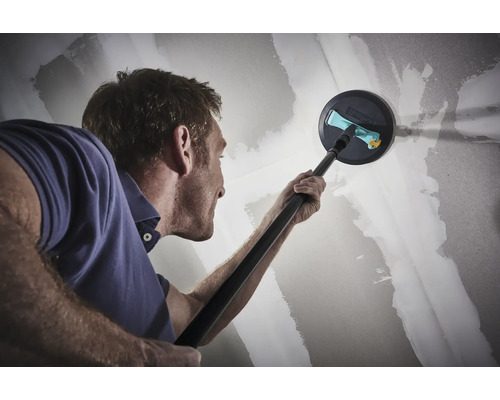 Ein Mann schleift eine Trockenbauwand mit einem Langhalsschleifer.