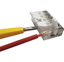 Transparente Verbindungsklemme mit Hebel bei der Installation eines roten Kabels mit Hilfe eines gelben Werkzeugs.