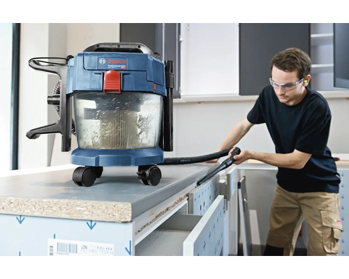 Bosch Akku-Nass-Trockensauger im Einsatz beim Reinigen einer Werkbank in einer hellen Werkstatt.