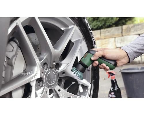 Anwendung der elektrischen Reinigungsbürste Bosch UniversalBrush zur Reinigung einer Aluminiumfelge mit Seifenwasser.