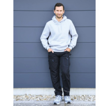 Mann trägt einen hellgrauen Hoodie und eine schwarze Arbeitshose mit blauen Details.