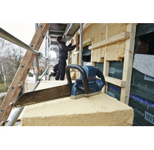 Bosch Elektrofuchsschwanz für Dämmstoffe auf einer Baustelle mit Handwerker bei der Fassadendämmung.