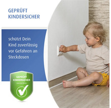 Kleinkind sitzt am Boden und greift nach einer Steckdose mit Kindersicherung. Geprüfte Kindersicherheit für Steckdosenschutz.