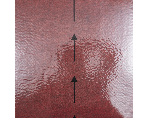 Strukturierte rote Oberfläche eines Baumaterials mit schwarzen Pfeilen zur Anzeige der Verlegerichtung.