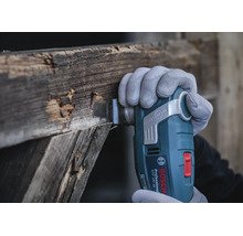 Bosch Professional Akku Multifunktionswerkzeug GOP 18V-34 beim Schneiden von altem Holz mit einem Starlock Plus Einsatz.