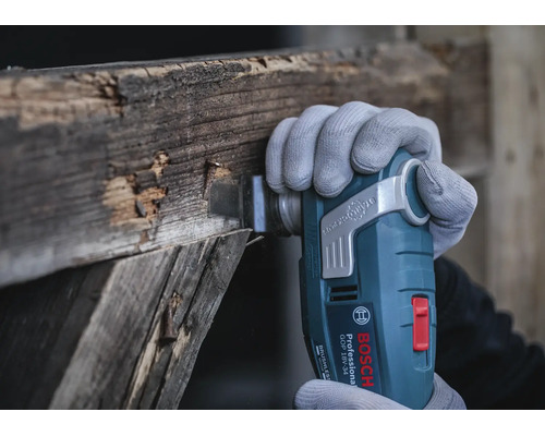 Bosch Professional Akku Multifunktionswerkzeug GOP 18V-34 beim Schneiden von altem Holz mit einem Starlock Plus Einsatz.