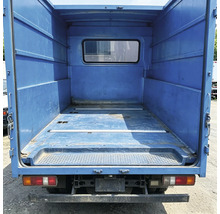 Leere Ladefläche eines Transporters mit Metallwänden und einem Fenster in der Trennwand.