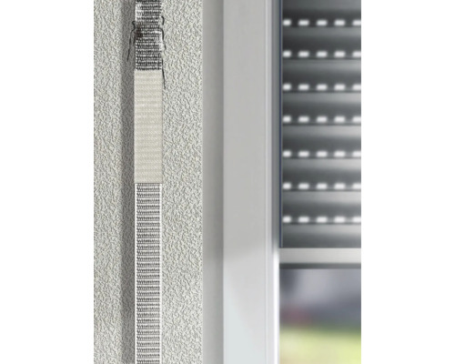Anwendung eines Reparatursets für Rollladengurte an einem Fenster mit heruntergelassenem Rollladen.