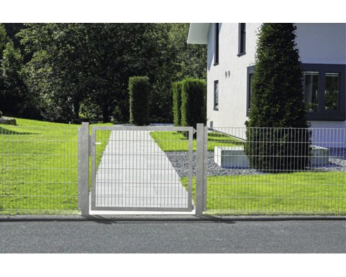 Gartentor aus Doppelstabmatte in einer Zaunanlage vor einem Haus mit gepflastertem Weg und Rasen.