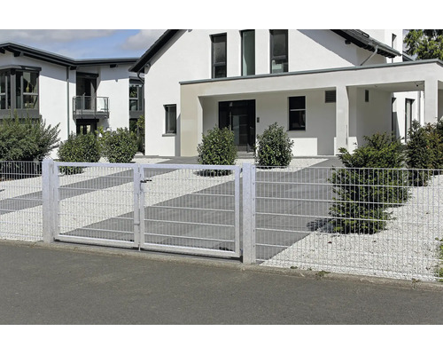 Zweiflügeliges Doppelstabmatten-Einfahrtstor und passender Zaun vor einem modernen Wohnhaus mit Kiesgarten und Sträuchern.