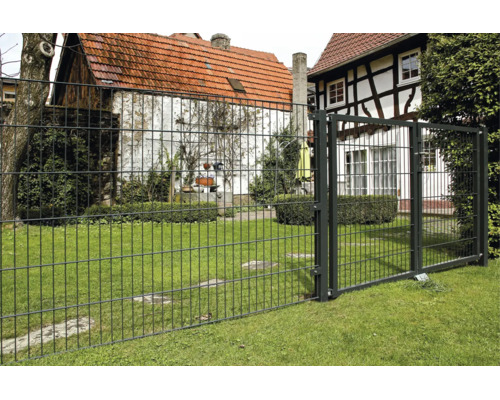 Anthrazitfarbener Doppelstabmattenzaun und Tor aus Metall in einem hellen, gepflegten Garten auf einer Rasenfläche.
