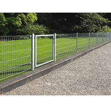 Moderner Doppelstabmattenzaun aus verzinktem Metall mit Gartentor auf einer organisierten Rasenfläche mit Kiesweg und Steineinfassung.