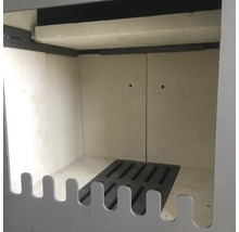 Innenraum eines Kaminofens mit Schamottsteinauskleidung und Ascherost aus Gusseisen.