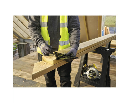 Person in Warnweste markiert mit einem Stanley Dachsparrenwinkel und Bleistift einen Holzbalken auf einer Baustelle.