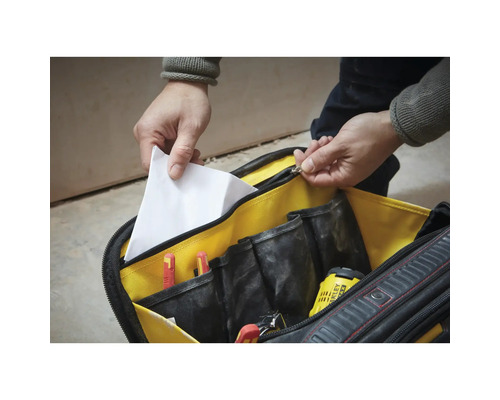 Geöffnete Werkzeugtasche mit mehreren Innenfächern, Schraubendrehern, Bohrer und einem Dokument.