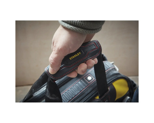 Hand am gepolsterten Tragegriff einer Stanley Werkzeugtasche mit roten Ziernähten.