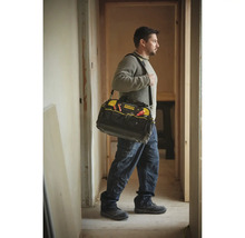 Handwerker trägt eine Stanley FatMax Werkzeugtasche mit Schultergurt in einem hellen Flur während Renovierungsarbeiten.
