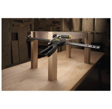 Stanley FatMax Einhandzwinge fixiert Holzbauteile auf einer Werkbank in einer Werkstatt.