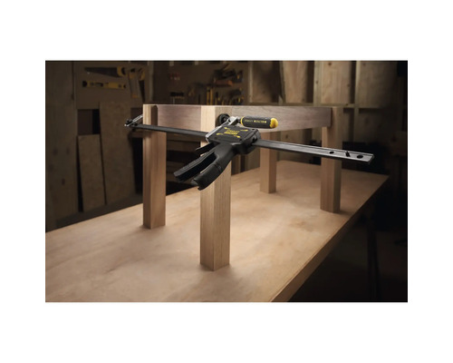 Stanley FatMax Einhandzwinge fixiert Holzbauteile auf einer Werkbank in einer Werkstatt.