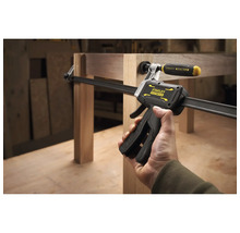 Stanley FatMax Einhandzwinge fixiert Holzbauteile an einem Möbelstück in einer Werkstatt.