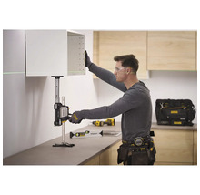 Ein Handwerker nutzt einen Stanley TradeLift zum präzisen Anheben eines Küchenschranks in einer hellen Küche mit Holzelementen.