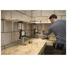 Ein Mann montiert Holzregale in einer Werkstatt mit Stanley Trade Lifts zur Unterstützung, einer Wasserwaage und einem Maßband.