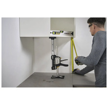 Montage eines Wandschranks mit dem Stanley FatMax Trade Lift zur Abstützung, einer Wasserwaage und einem Maßband in einer hellen Küche.